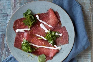 Carpaccio van het rood ras van West-Vlaanderen met West-Vlaamse gerookte sprot